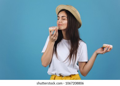 Brunette Girl Tastes A Donut Posing In A Hat