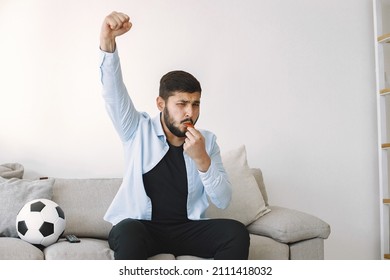 Brunette Guy Sitting On A Coach And Watching Football At Home