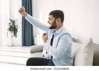 Brunette Guy Sitting On A Coach And Watching Football At Home