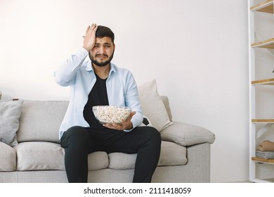 Brunette Guy Sitting On A Coach And Watching Football At Home