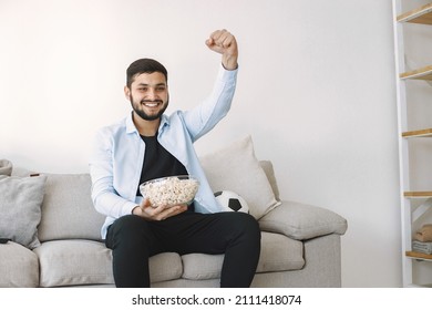 Brunette Guy Sitting On A Coach And Watching Football At Home