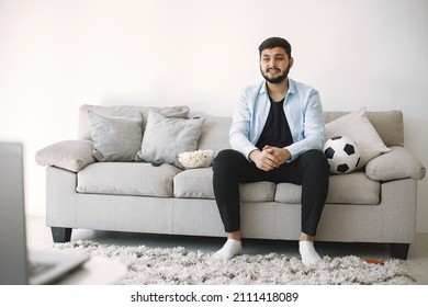 Brunette Guy Sitting On A Coach And Watching Football At Home