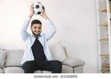 Brunette Guy Sitting On A Coach And Watching Football At Home