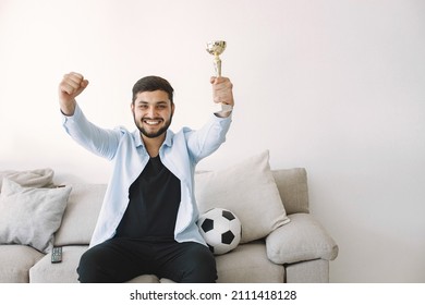 Brunette Guy Sitting On A Coach And Watching Football At Home