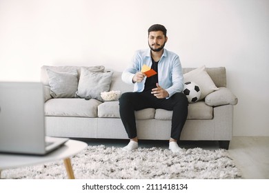 Brunette Guy Sitting On A Coach And Watching Football At Home