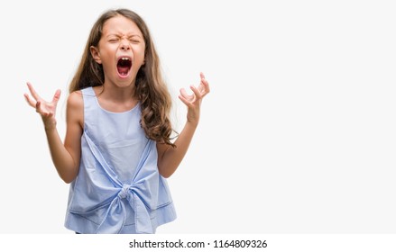 Brunette hispanic girl crazy and mad shouting and yelling with aggressive expression and arms raised. Frustration concept.