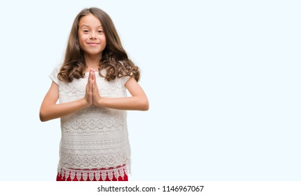 Brunette Hispanic Girl Praying With Hands Together Asking For Forgiveness Smiling Confident.