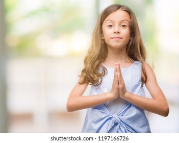 Brunette Hispanic Girl Praying With Hands Together Asking For Forgiveness Smiling Confident.