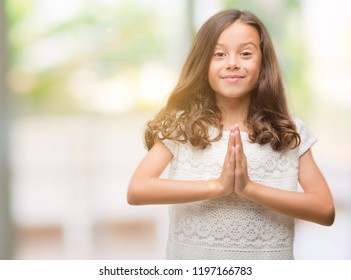 Brunette Hispanic Girl Praying With Hands Together Asking For Forgiveness Smiling Confident.