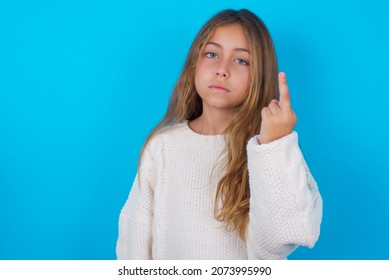 Brunette Kid Girl Wearing Knitted Sweater Over Blue Background  Shows Middle Finger Bad Sign Asks Not To Bother. Provocation And Rude Attitude.