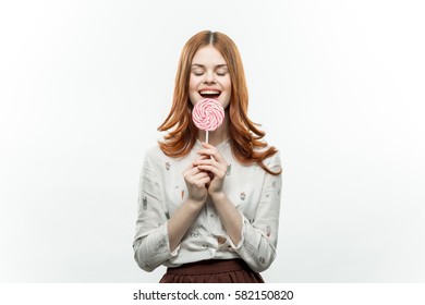 brunette with a lollipop in her hand  smiling.