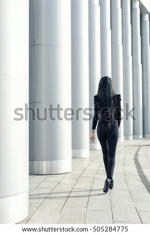 brunette with long legs near the columns