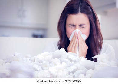 Brunette Sneezing In A Tissue Against Used Tissues