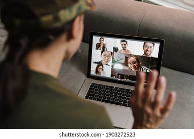 Brunette Soldier Woman Waving Hand While Making Conference Call On Laptop Indoors