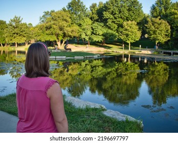 Brunette standing by the reflective waters of Sar Ko Par Park in Lenexa Kansas
