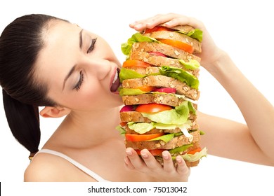 Brunette Taking A Big Bite Out Of Huge Sandwich On White Background