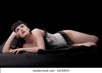 Brunette In Victorian Corset On Black Sheets