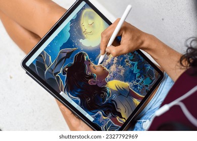 Brunette woman artist and illustrator drawing, using electronical tablet and stylus