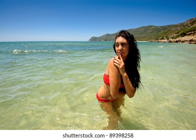 Brunette Woman At The Beach On The Water With Goosebumps Caused By The Cold Water