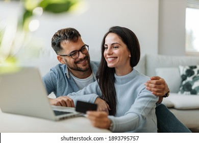 Brunette woman checking her bank account online, together with her husband.