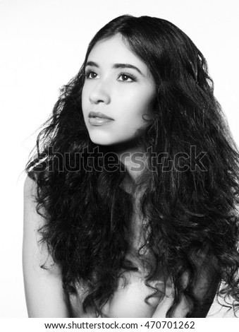 Brunette woman with curly teased hair and smokey eyes.