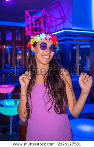 Brunette woman dancing at a night club party in purple glasses at a pub party