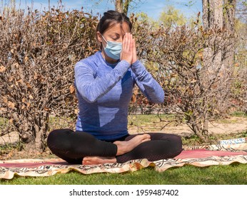 A Brunette Woman Doing Yoga Class In A Park On A Sunny Day And Wearing A Face Mask