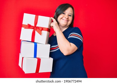 Brunette woman with down syndrome holding gifts smiling and laughing hard out loud because funny crazy joke. 
