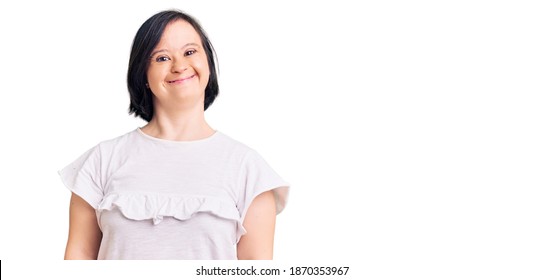 Brunette woman with down syndrome wearing casual white tshirt with a happy and cool smile on face. lucky person. 