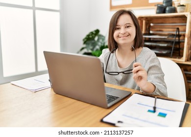Brunette woman with down syndrome working using laptop at business office - Shutterstock ID 2113137257