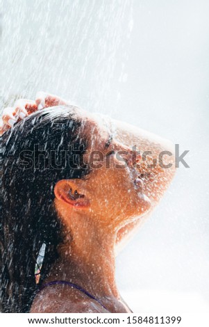 Brunette woman enjoying a shower outdoor