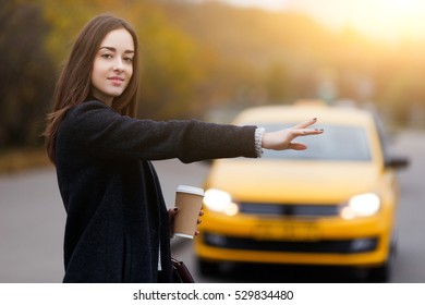 Brunette woman hand gesture catches taxi. Model looking at camera
