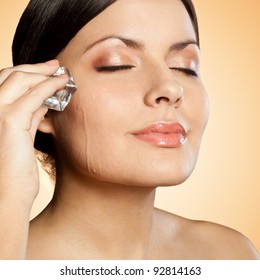 Brunette Woman Holding Ice Cube On Her Face, Closeup Portrait