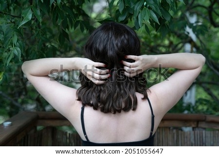 brunette woman in nature in a forrest from behind 