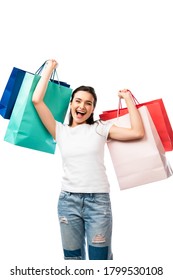 brunette woman with open mouth holding shopping bags isolated on white