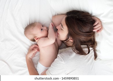 Brunette Woman Playing With Baby. Mom Hugging Baby Closeup