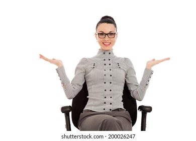 brunette woman in shirt and trousers sitting in office chair presenting something over white background