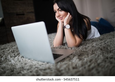 Brunette Woman Watch Movie On Laptop At Home On Carpet