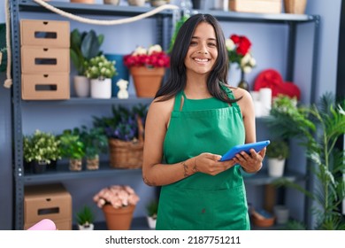 Brunette woman working at florist shop holding tablet smiling with a happy and cool smile on face. showing teeth.  - Powered by Shutterstock