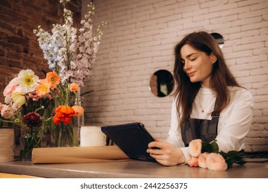 Brunette woman working at florist shop holding tablet smiling with a happy and cool smile on face. showing teeth. . High quality photo - Powered by Shutterstock