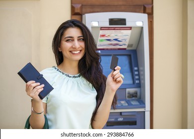 Brunette Young Lady Using An Automated Teller Machine . Woman Withdrawing Money Or Checking Account Balance