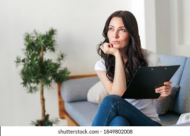 Brunette Young Woman Fills In The Information In The Questionnaire Making An Application For Hire On Vacancy. The Woman Is Planning The Interior Design Of The House.