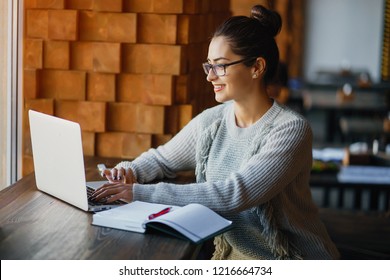 brunetter woman working on her laptop at a restaurant - Shutterstock ID 1216664734