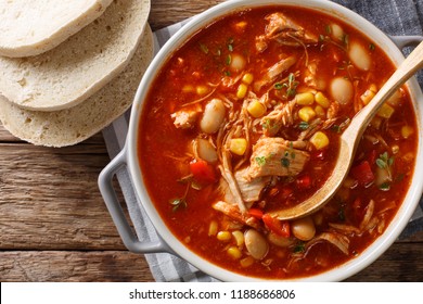 Brunswick Stew - thick, flavorful and hearty one-pot stew with vegetables and meat on a chicken broth and BBQ sauce close-up in a bowl on the table. Horizontal top view from above
