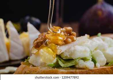 bruschetta with cheese, fruit and nuts is drizzled with honey. macro - Powered by Shutterstock