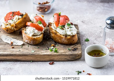 Bruschetta with cream cheese and tomato s on cutting board, rustic style
