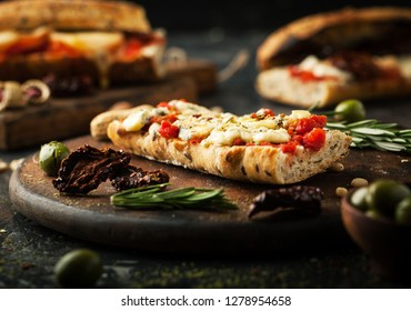 Bruschetta with dried tomatoes and cheese on a dark background - Shutterstock ID 1278954658
