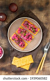 Bruschetta with pickled beet, apple and mayonnaise. Sandwich or crostini on a serving plate on a brown background. Crusty bread with traditional Scandinavian beetroot salad