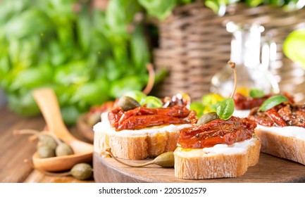 Bruschetta with sun-dried tomatoes, cheese, basil and capers. Traditional appetizer for aperitivo in Italy. High quality photo. Copy space - Shutterstock ID 2205102579