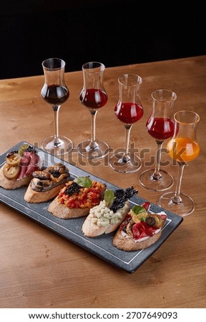 Bruschetta tasting set with assorted toppings and liqueur glasses.